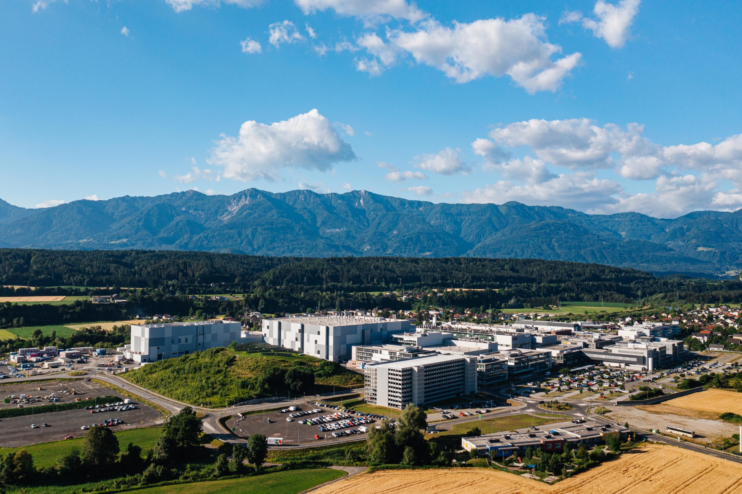 Landscape image of large semiconductor expansion build near mountains in Austria.